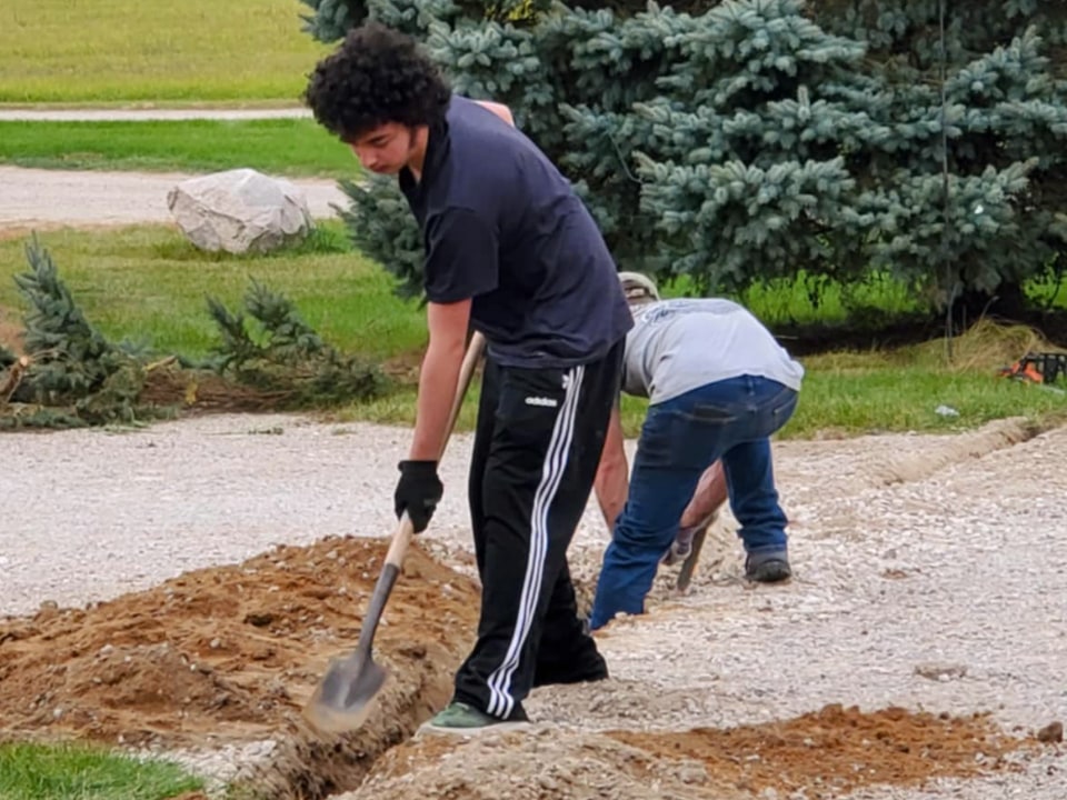 2 people digging A Trench.